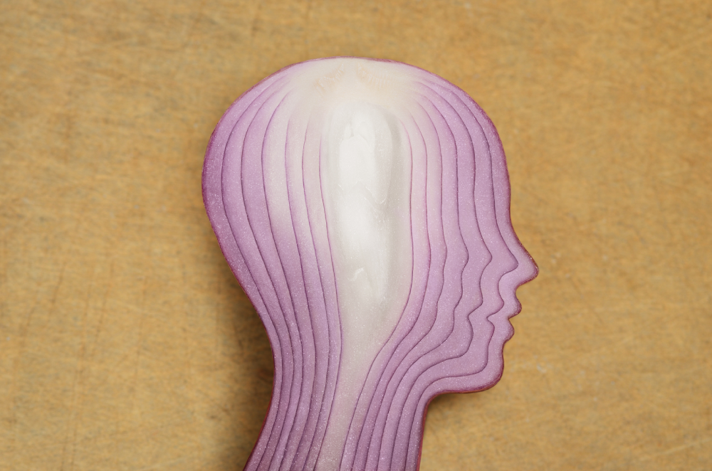 A cut-up red onion shaped like a human head profile